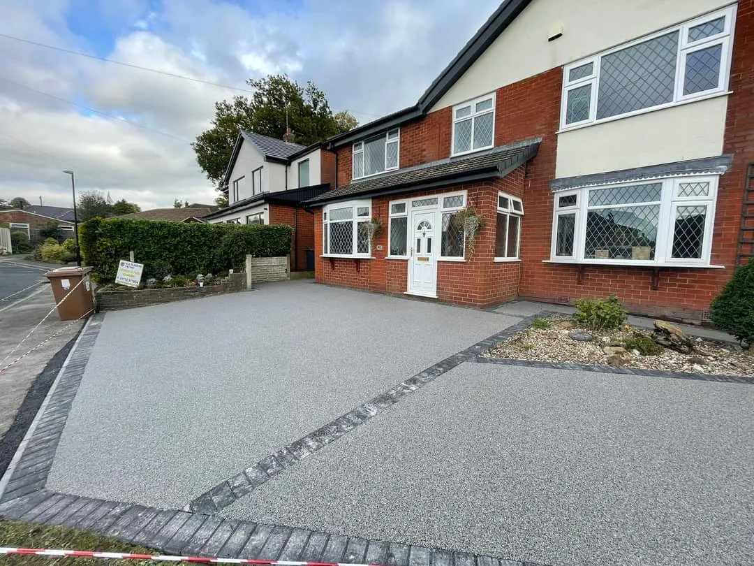 Grey resin driveway in front of a semi detached house